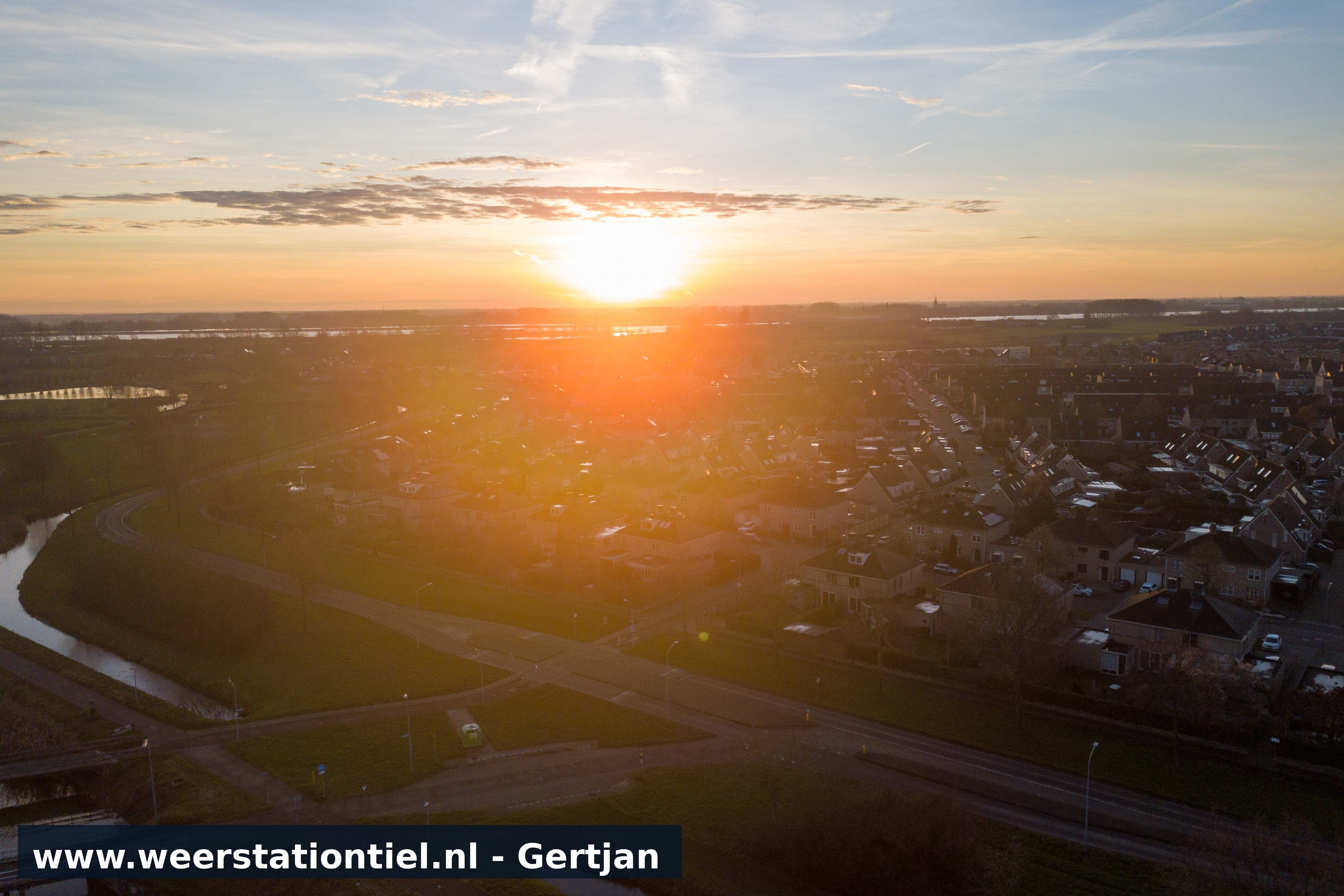 De zon komt op met Passewaaij op de voorgrond.